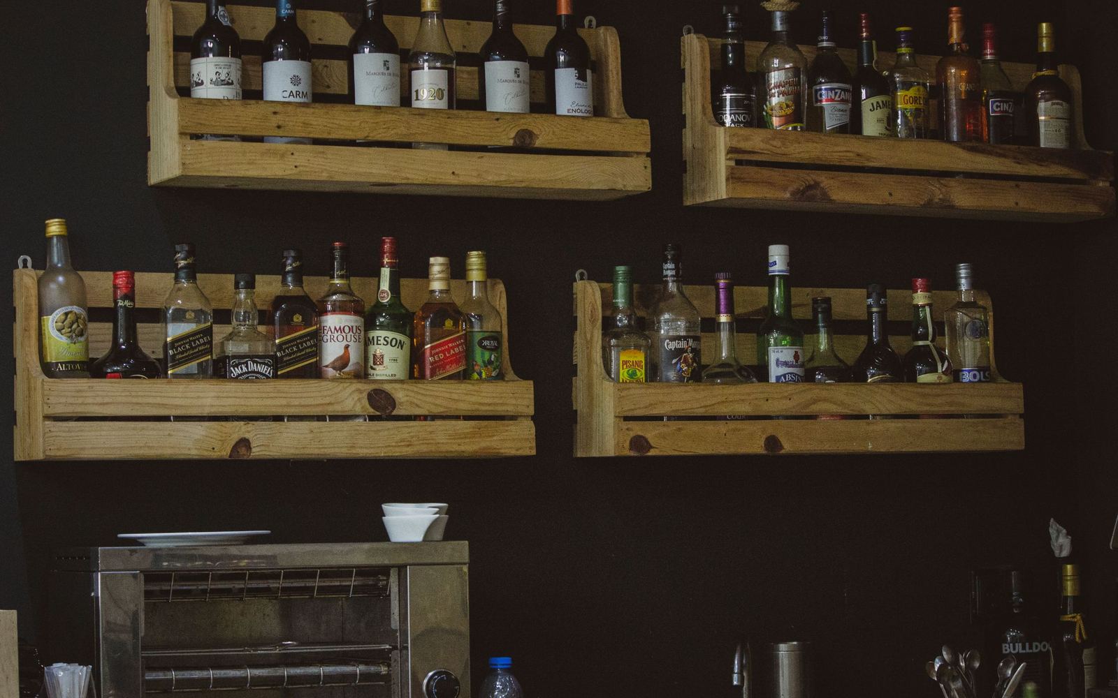Wooden shelves lined with bottles at Lou’s Liquors